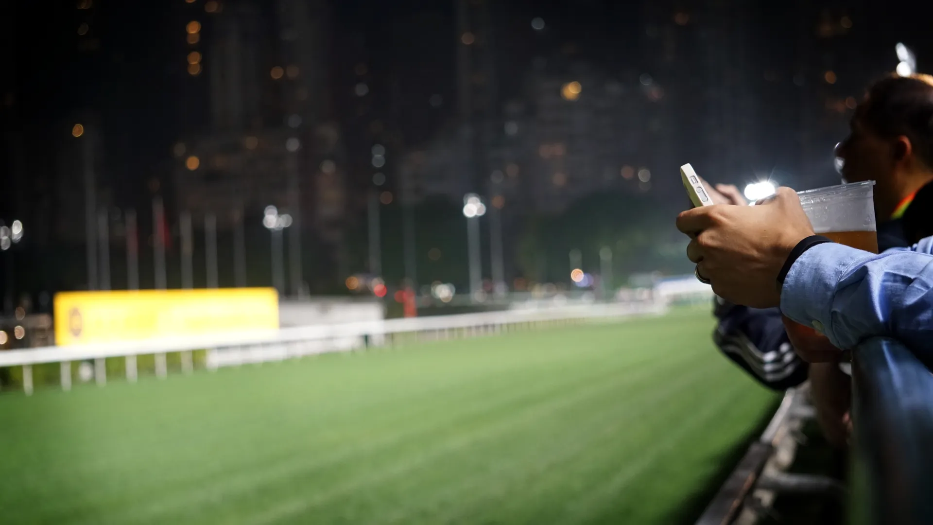 Horse racing spectators watching from the rail at a racecourse