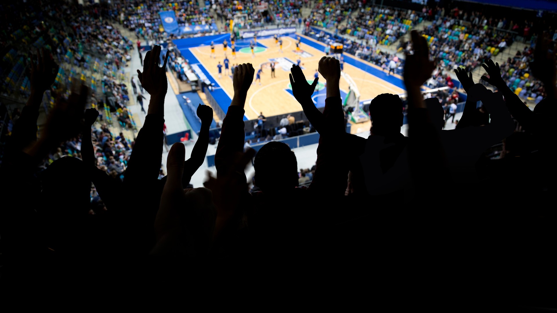 Arena crowd cheering during a basketball playoff game for a postseason travel comparison