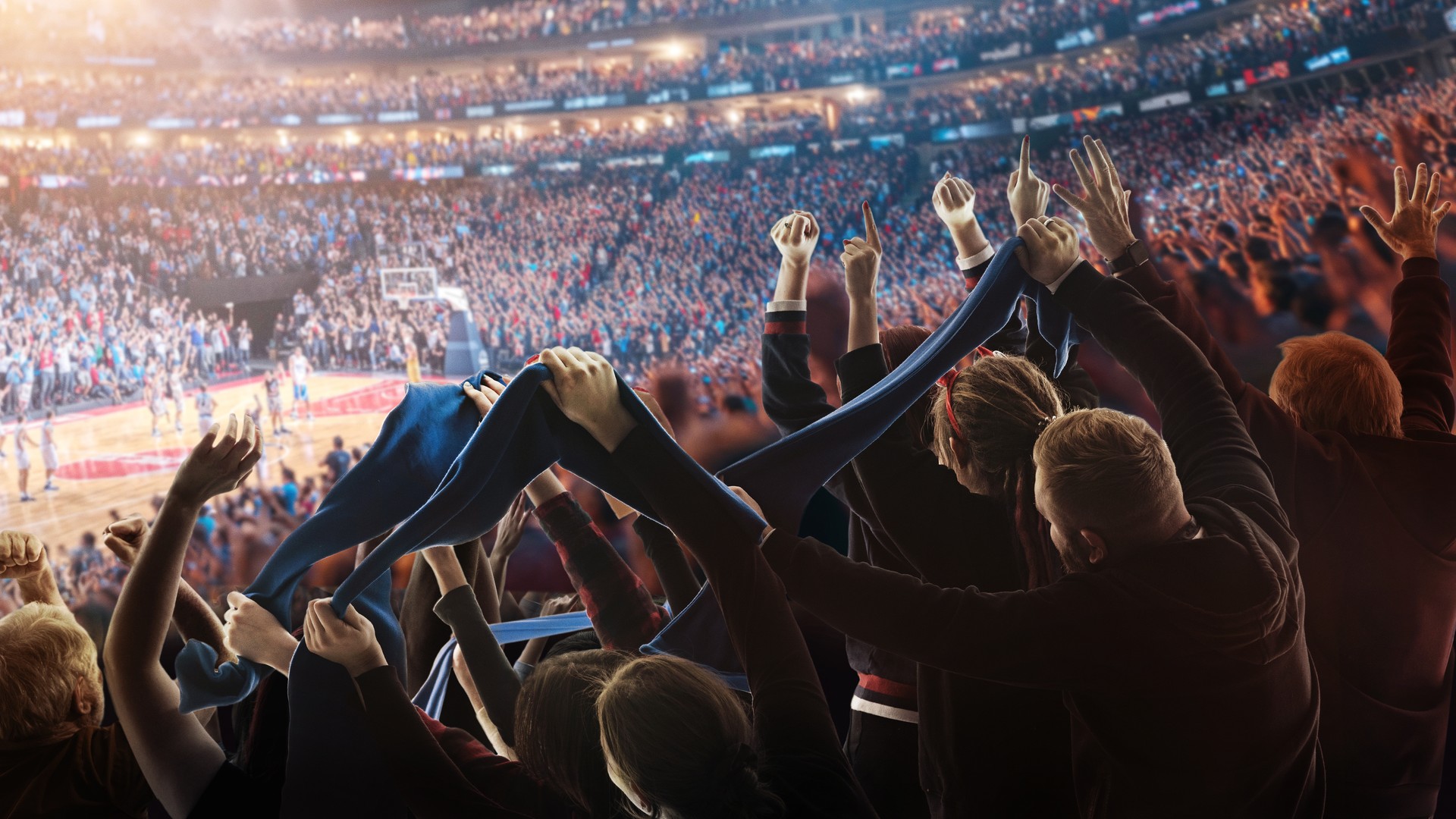 Basketball fans cheering inside a packed arena during a rivalry game