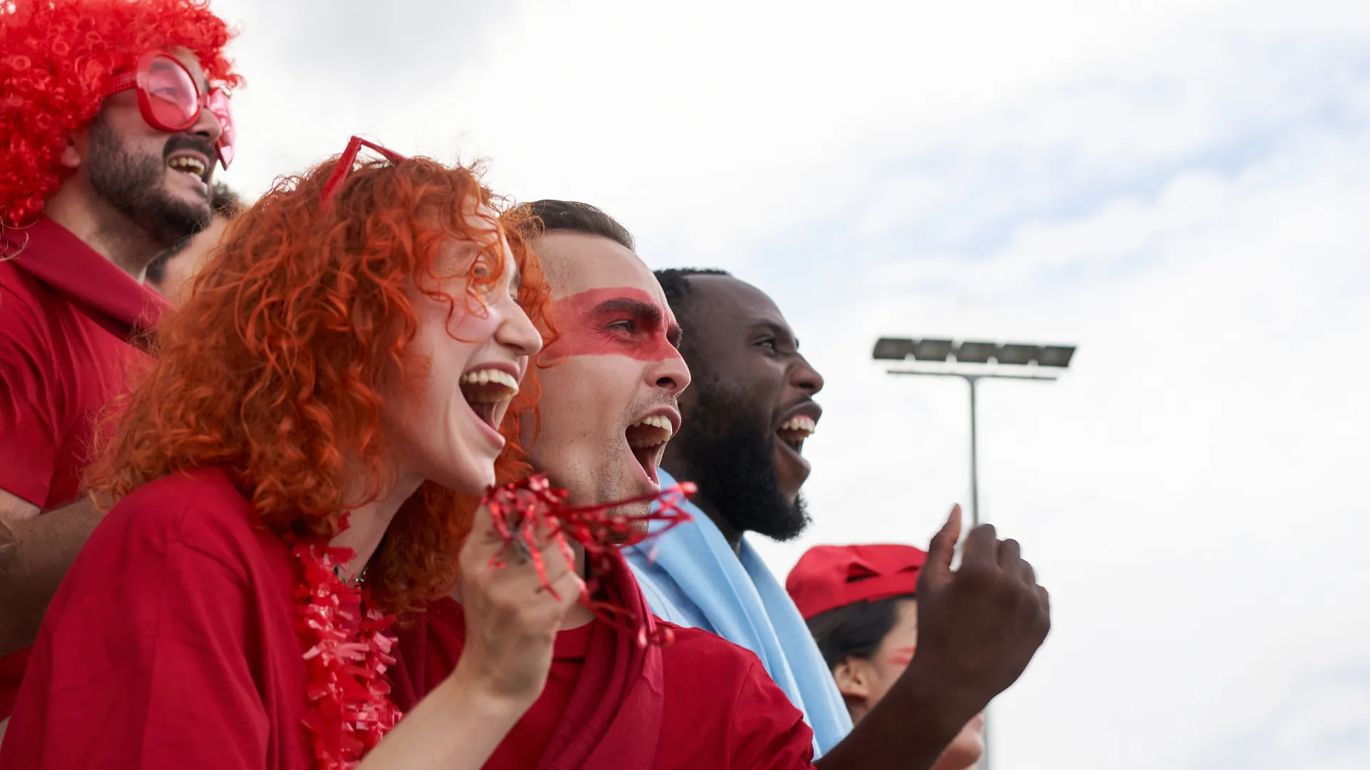 Excited fans cheering outdoors for a college football bowl destination travel guide