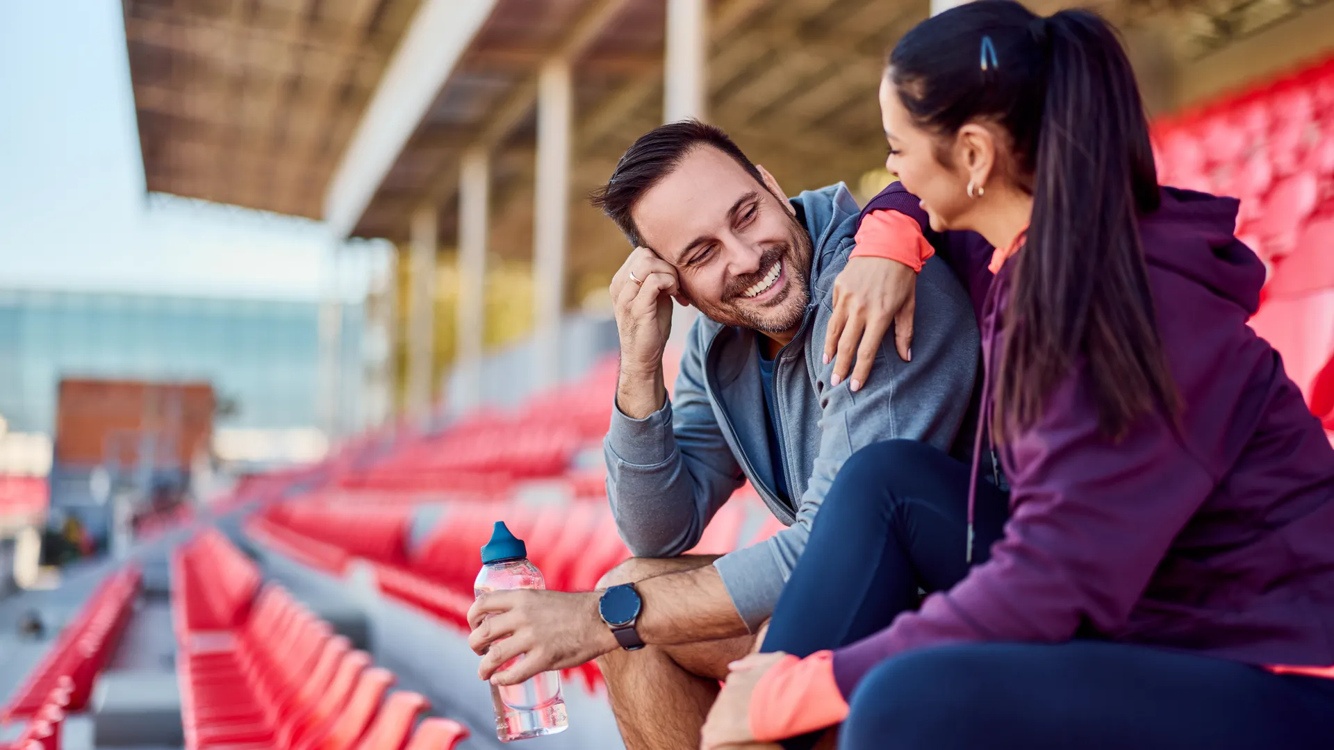 Couple enjoying a sports getaway together in stadium seats
