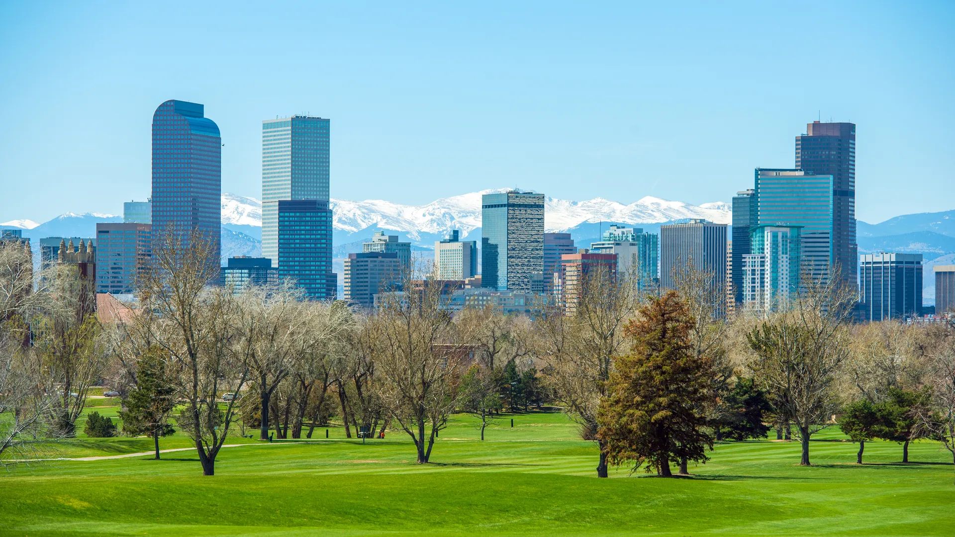 Denver skyline with Rocky Mountains for a Denver sports travel guide