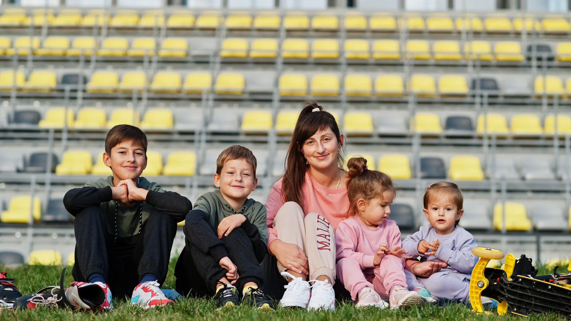 Family sitting together in front of stadium seats for kid-friendly sports vacations