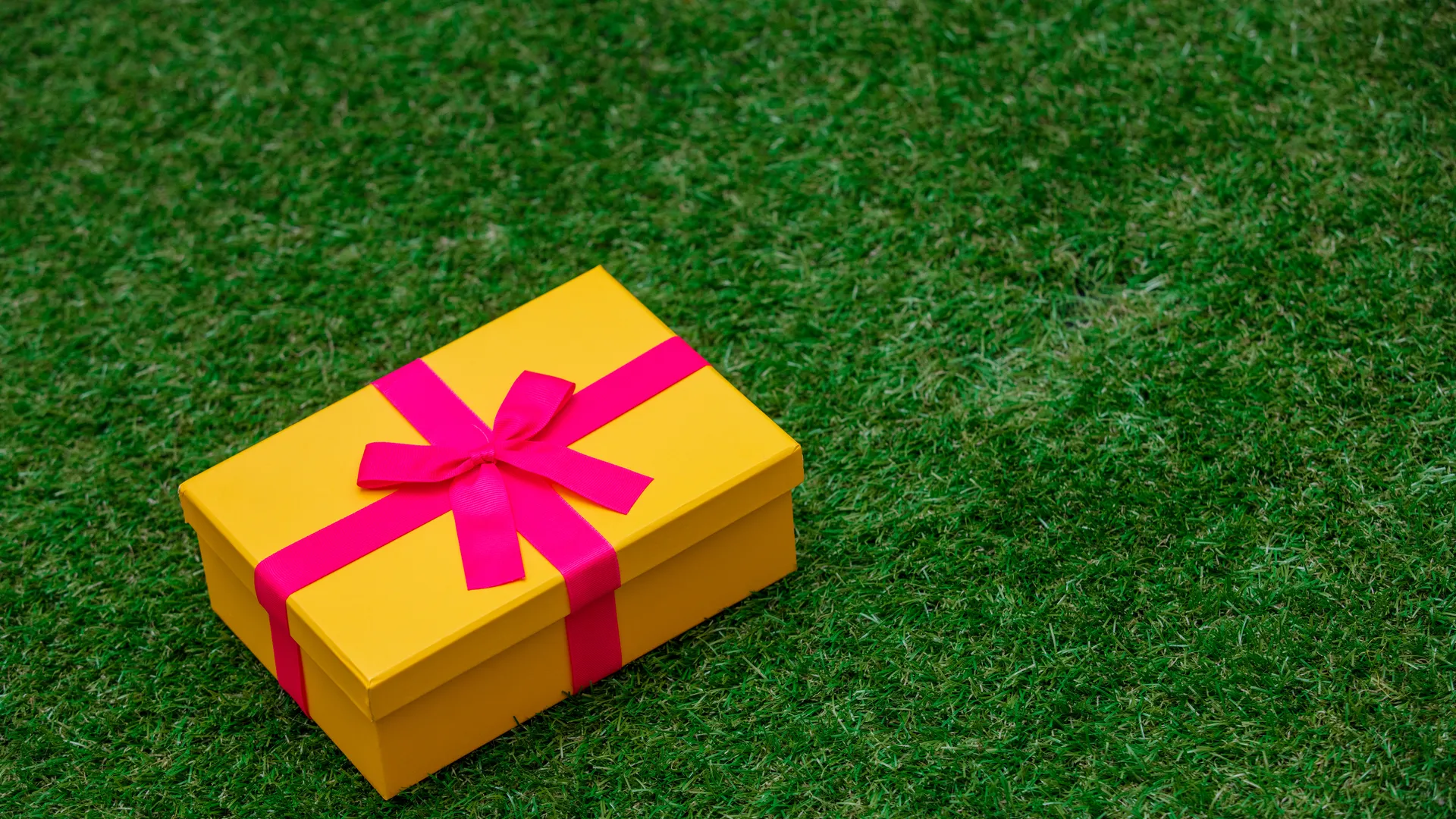 Gift box on green grass representing game-day experience gifts for sports fans