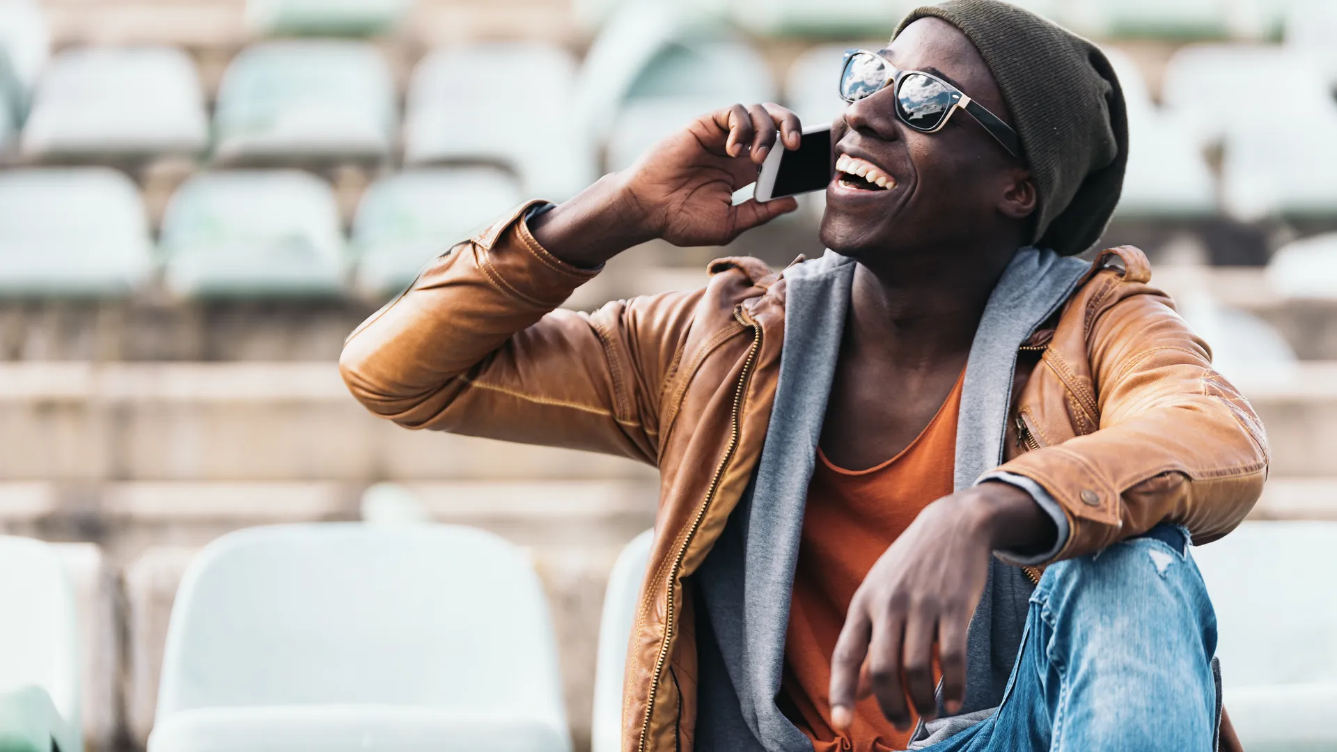Football fan using a phone in stadium seating for last-minute playoff trip planning