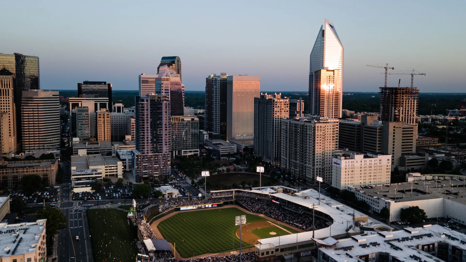 Baseball game at sunset near city high rises for an MLB All-Star Game host city travel guide