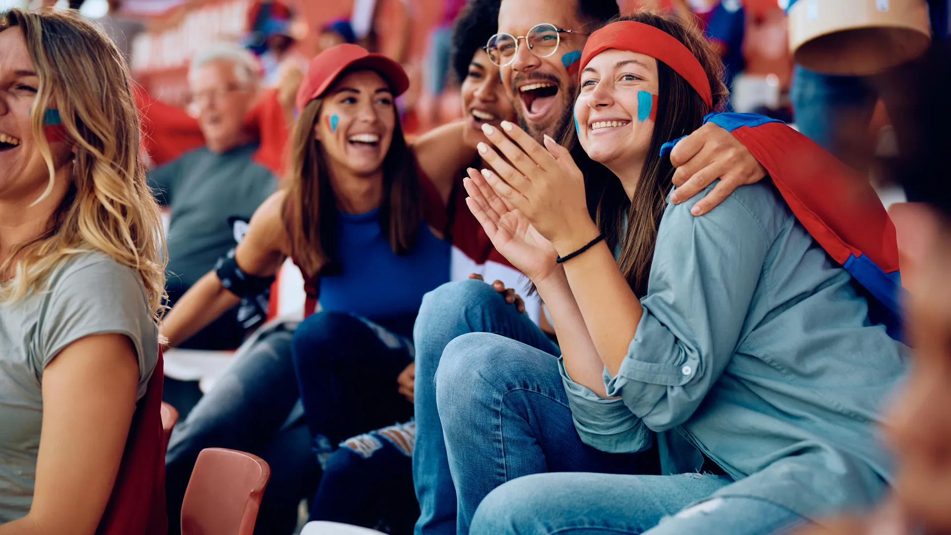 Fans celebrating a football playoff game in stadium seats