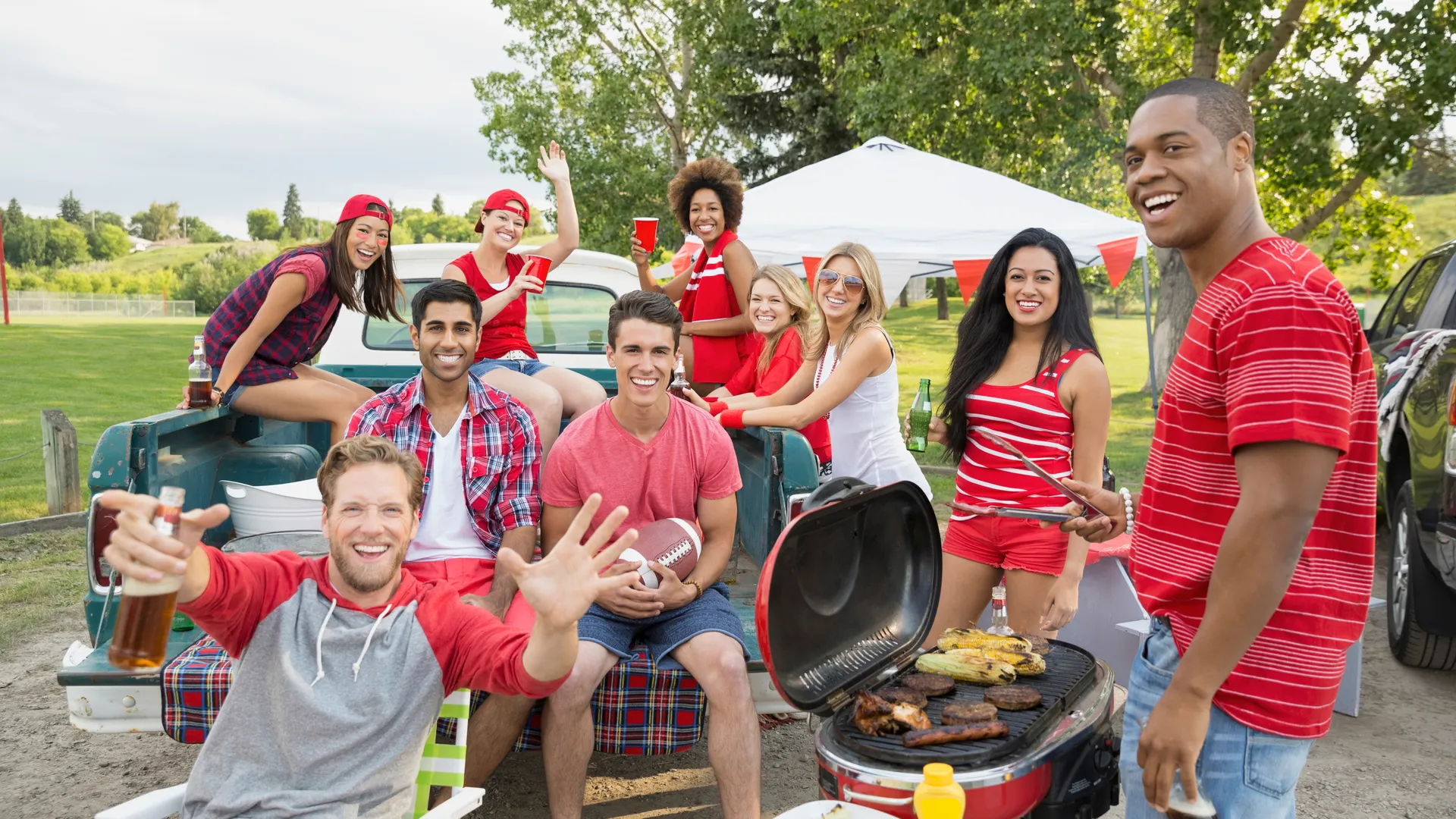 Friends cheering during a football tailgate barbecue