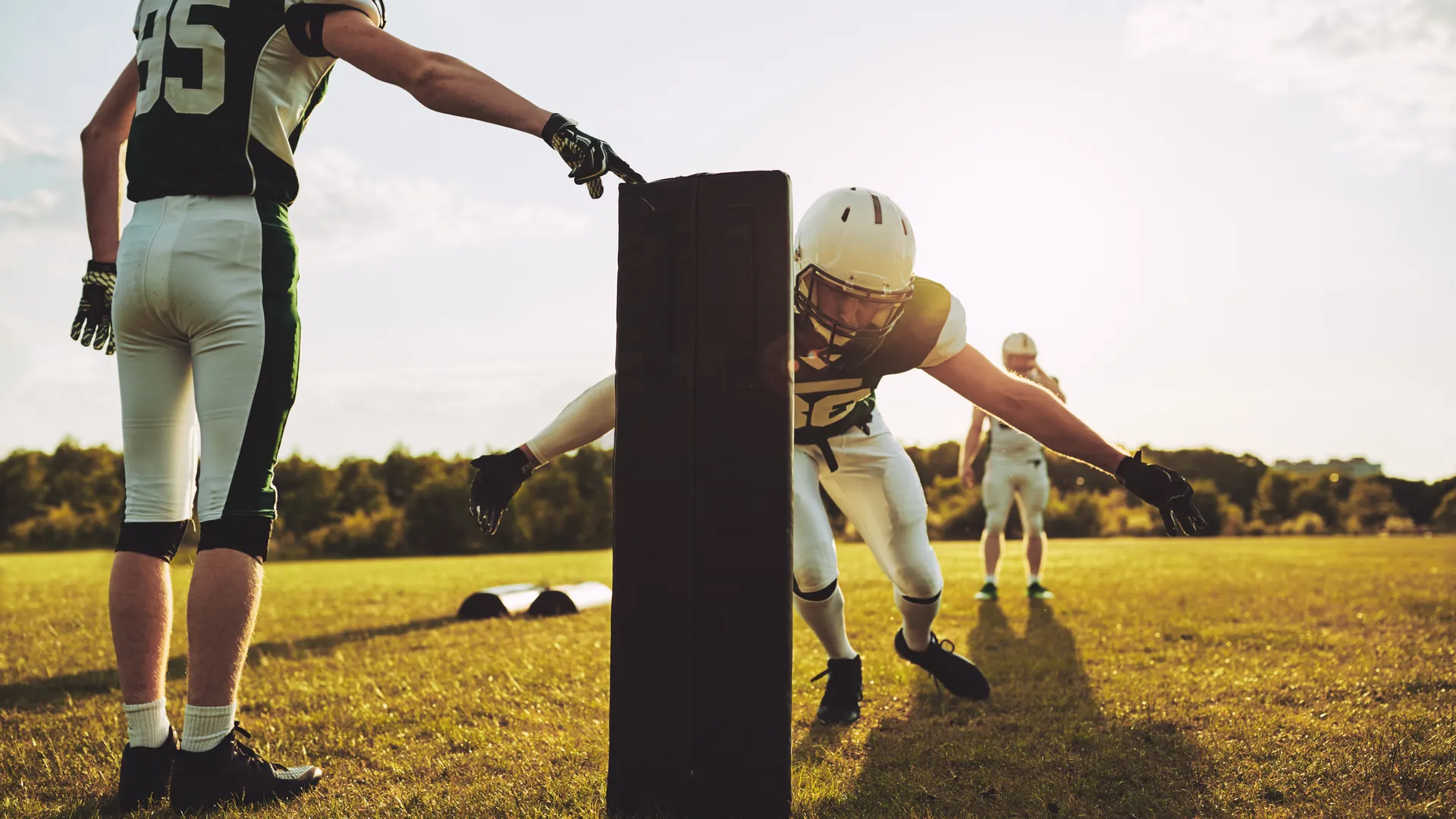 American football players doing tackling drills during training camp practice