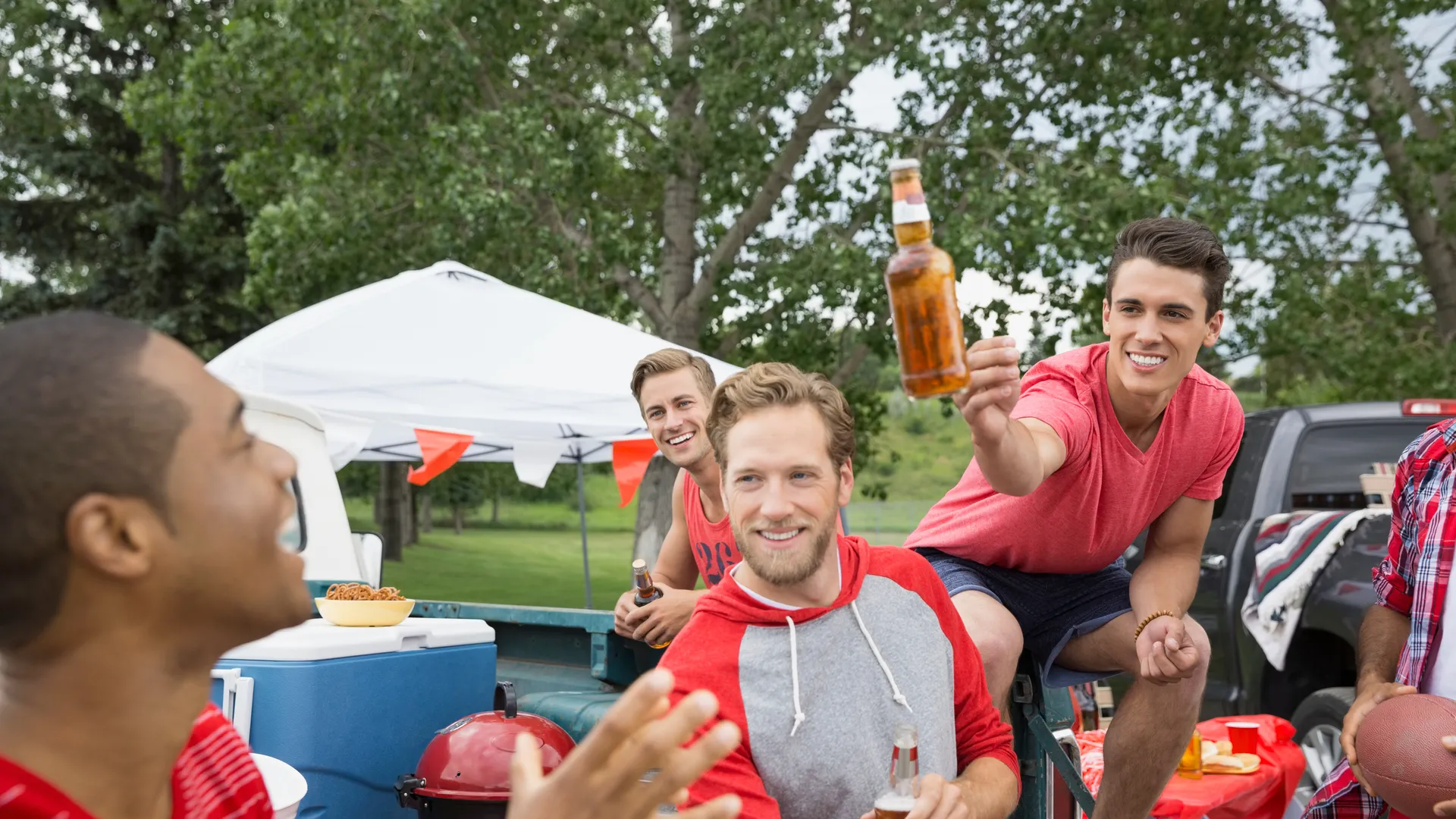 Football fans at a tailgate barbecue before a game-day experience