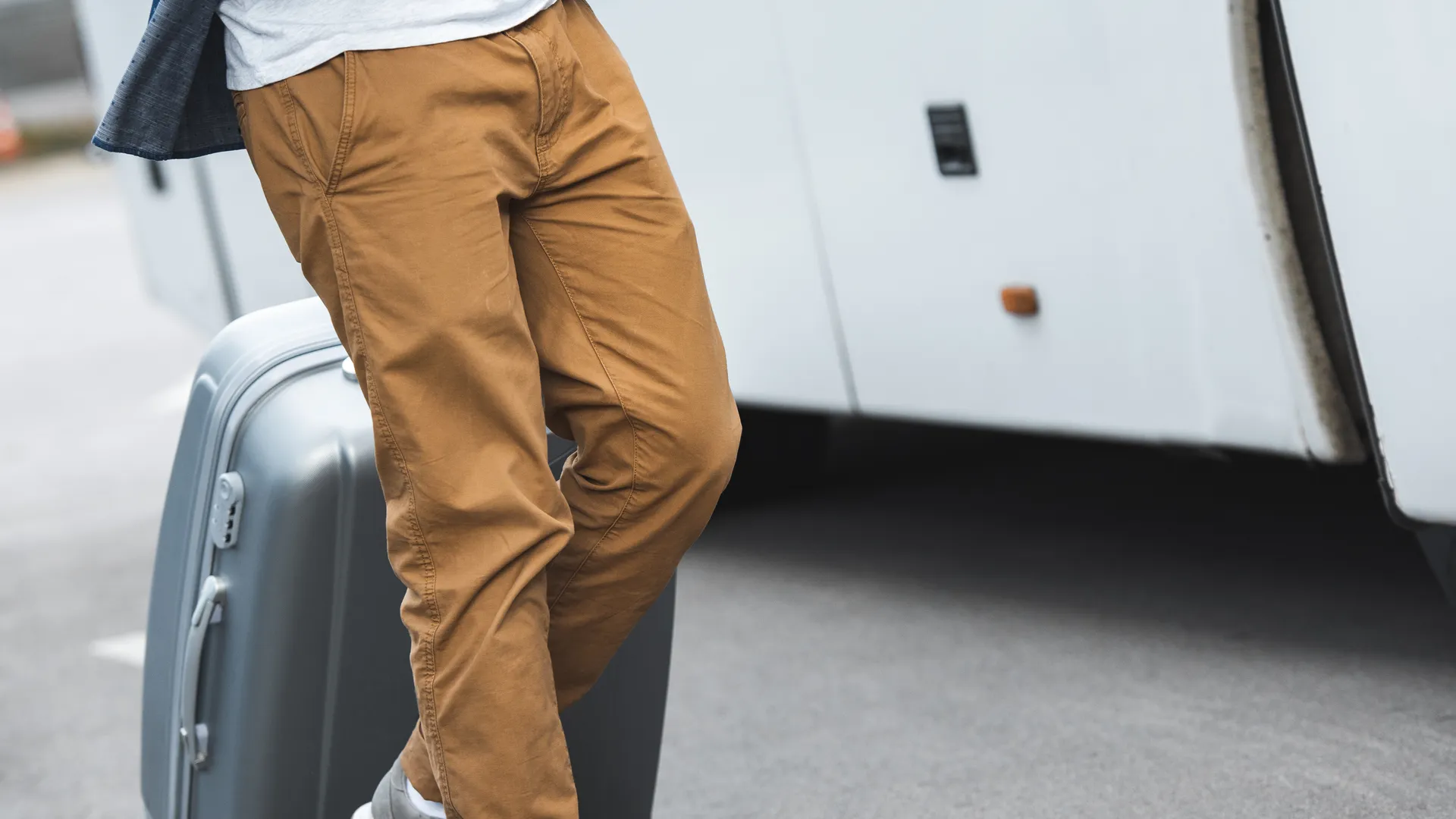 Sports traveler with luggage and a ball near a travel bus
