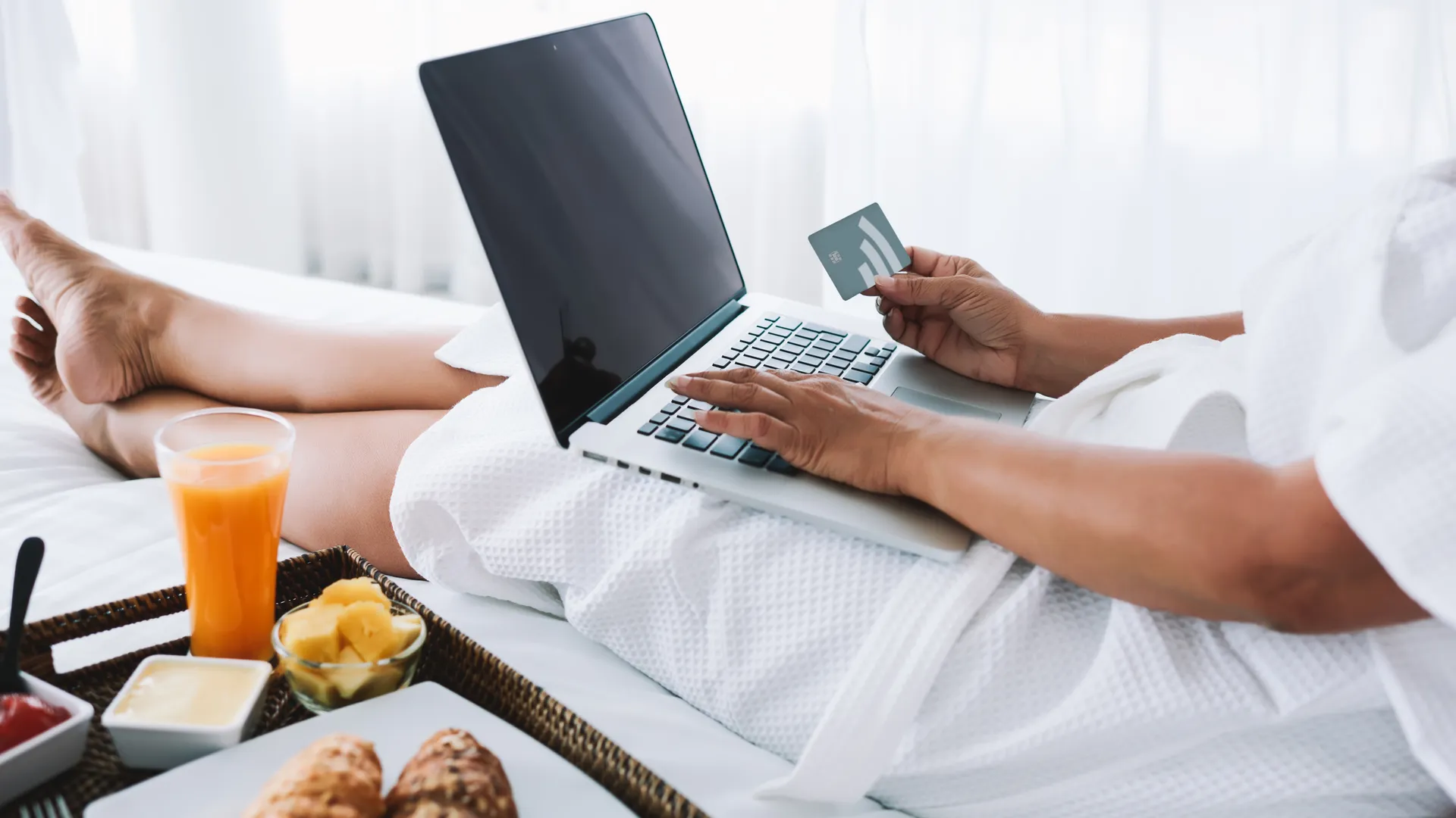Traveler booking a hotel stay online with a credit card for sports travel savings