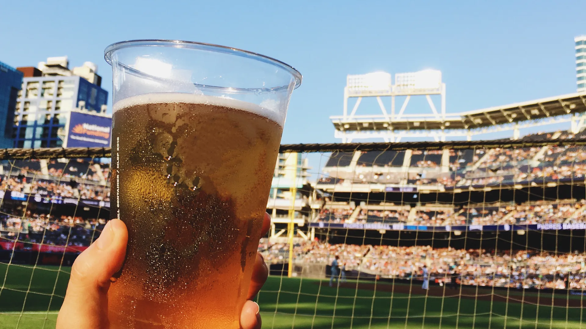 Cold drink at a sunny baseball game for a West Coast MLB ballpark road trip